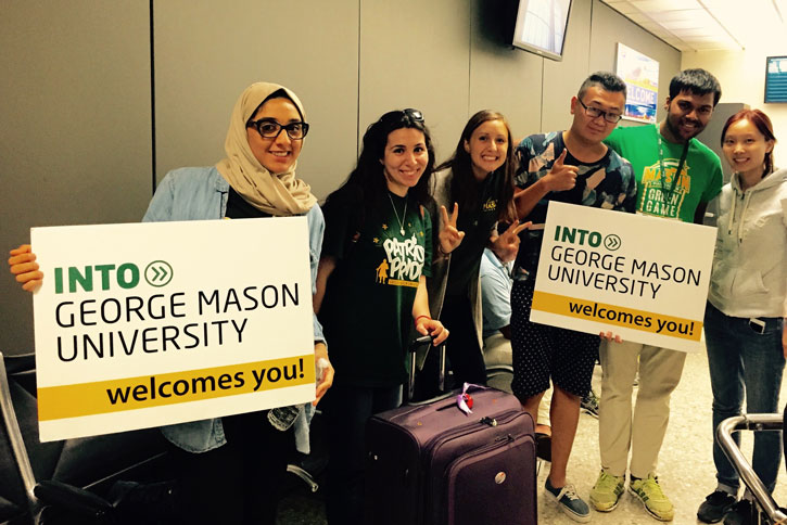 A group of INTO Mason students wait to greet classmates at the airport